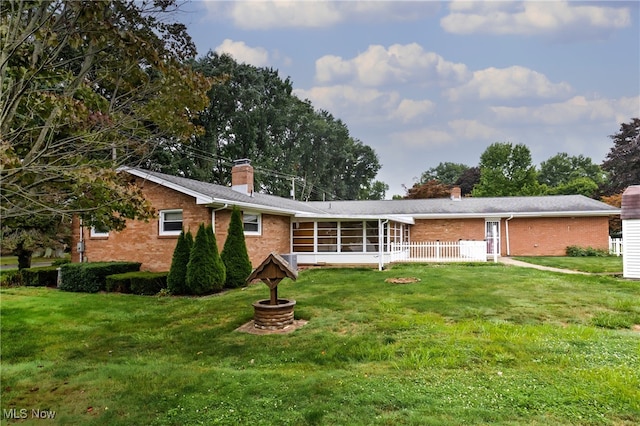 exterior space featuring a lawn and a sunroom