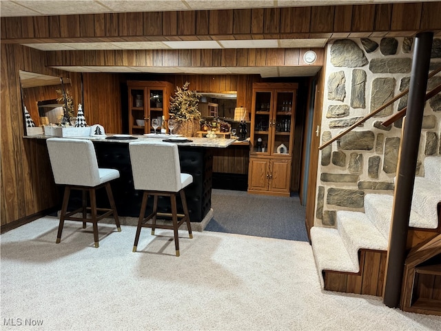 bar with wood walls and light colored carpet