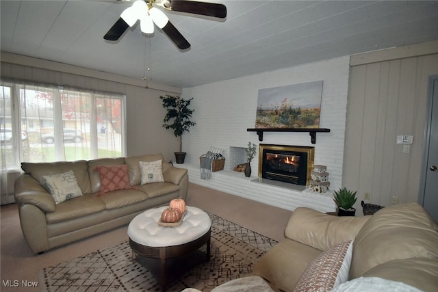 carpeted living room featuring ceiling fan and a brick fireplace