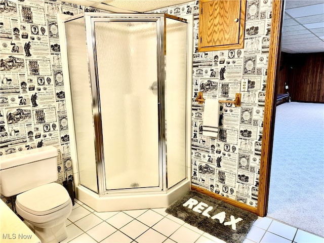 bathroom featuring tile patterned flooring, toilet, and an enclosed shower