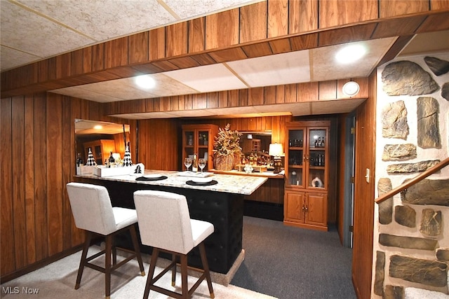 bar with carpet floors and wooden walls