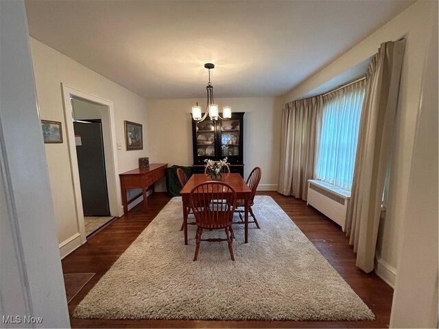 dining space with radiator, dark hardwood / wood-style flooring, and a chandelier