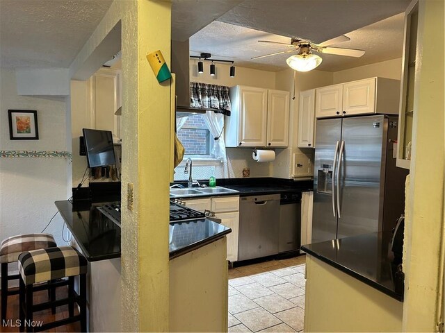 kitchen featuring a textured ceiling, ceiling fan, and appliances with stainless steel finishes