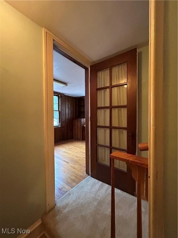 hallway featuring hardwood / wood-style flooring and wood walls