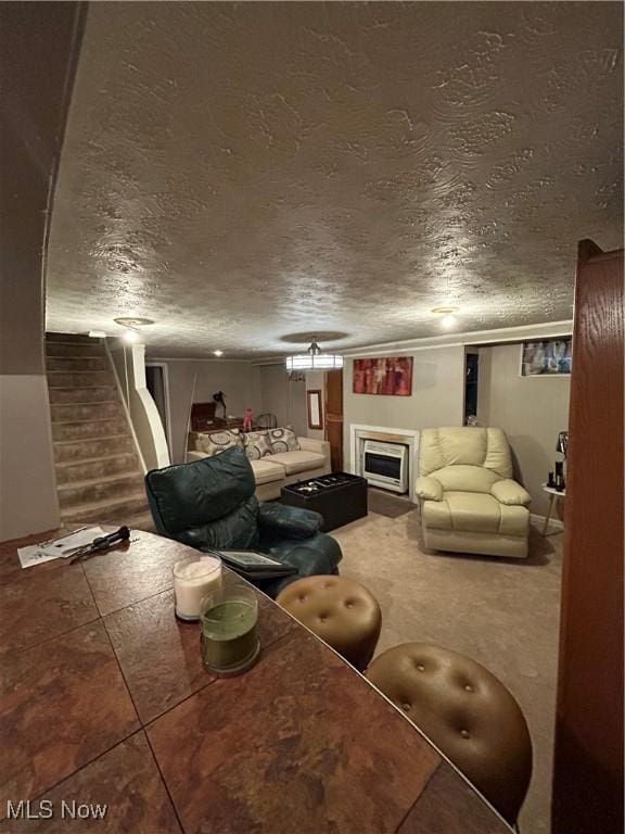 living area with a textured ceiling, stairway, a fireplace, and crown molding