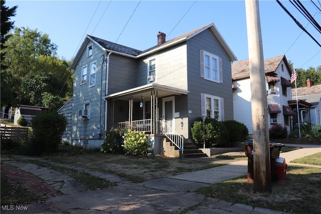 traditional-style house featuring covered porch and a chimney