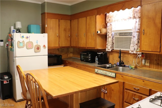 kitchen with wood walls, cooling unit, crown molding, sink, and white refrigerator