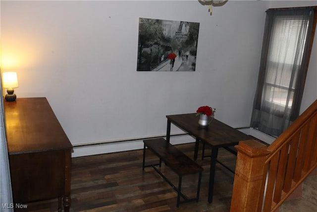 dining space featuring a baseboard radiator and wood finished floors