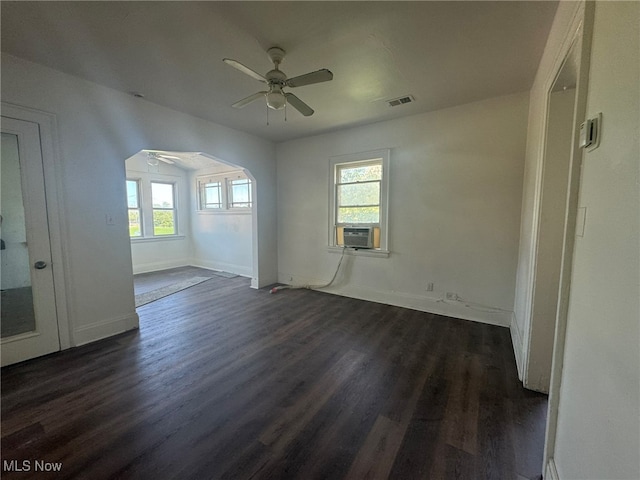 spare room featuring cooling unit, ceiling fan, and dark hardwood / wood-style flooring