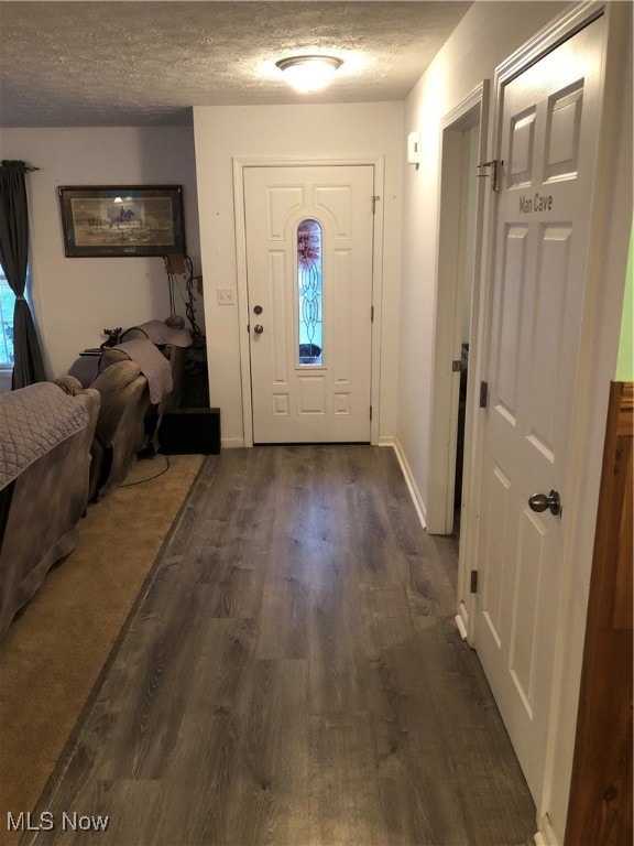 foyer entrance featuring dark hardwood / wood-style flooring and a textured ceiling