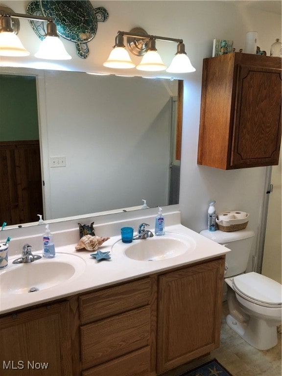 bathroom with tile patterned flooring, vanity, and toilet