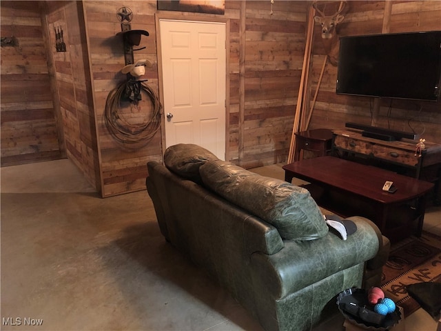 living room with wood walls and concrete flooring