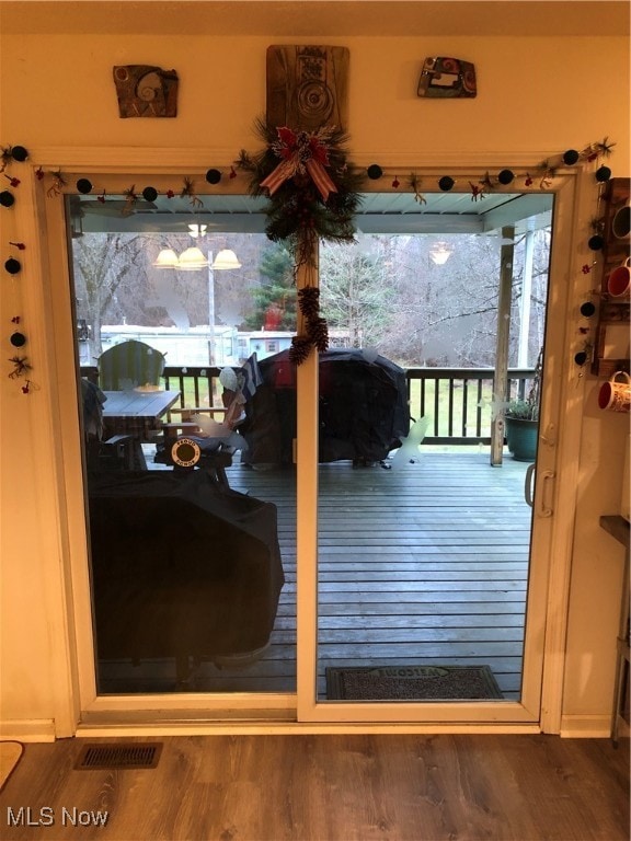 doorway to outside with a wealth of natural light and hardwood / wood-style flooring