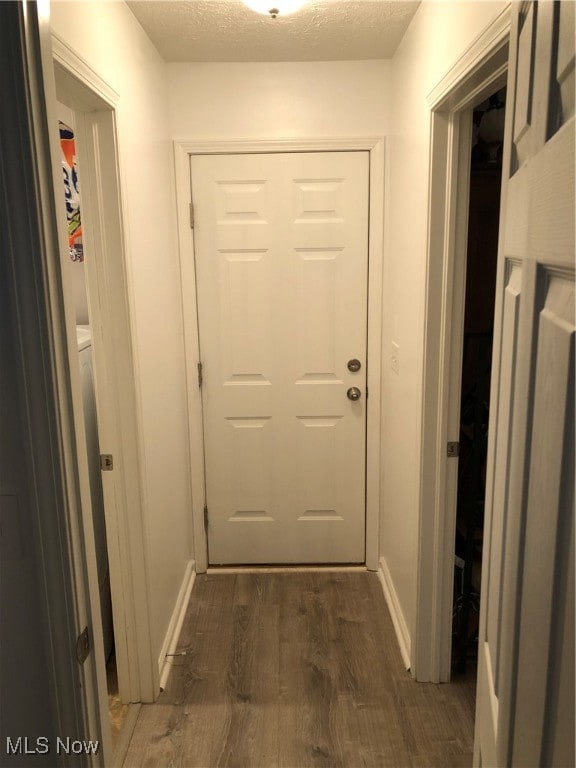 hallway featuring a textured ceiling and dark hardwood / wood-style floors