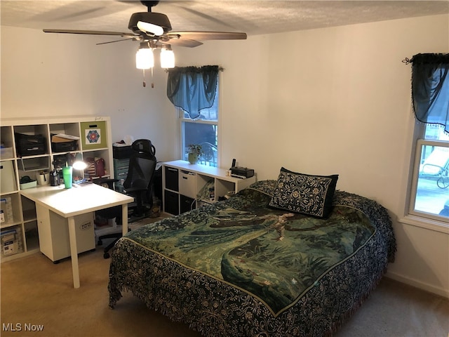 bedroom with a textured ceiling, ceiling fan, and carpet flooring