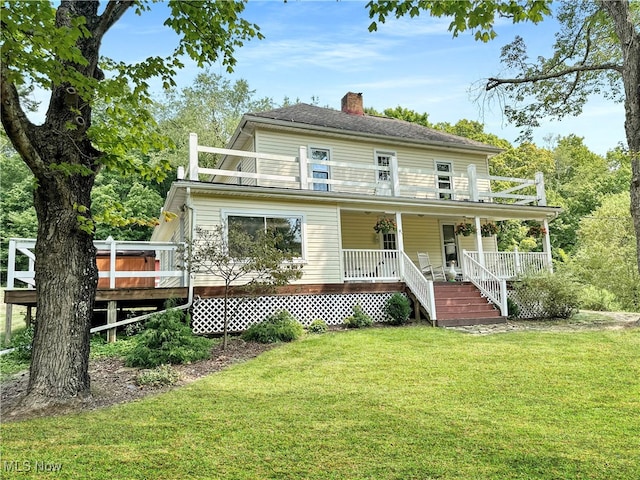 back of house featuring a lawn and a porch