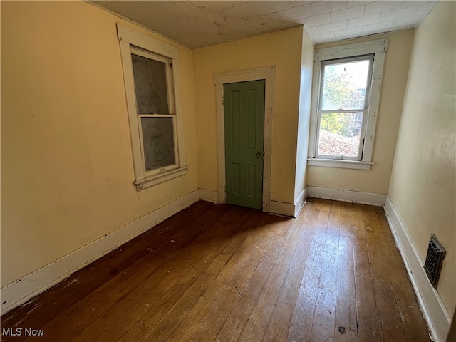 unfurnished room with hardwood / wood-style flooring