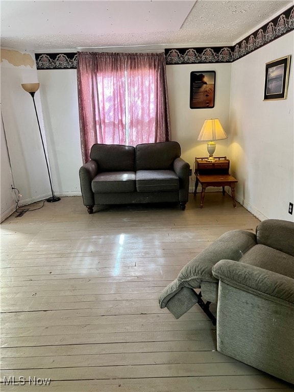 living room with light wood-type flooring and a textured ceiling