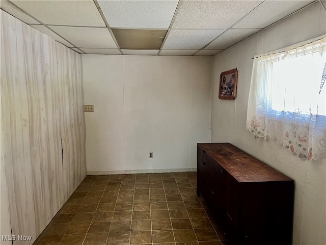 tiled empty room with a paneled ceiling