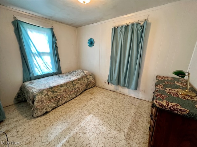 bedroom featuring wooden walls