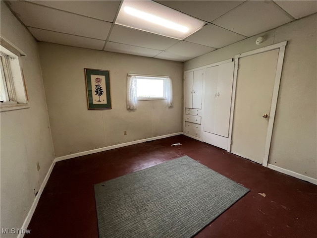 unfurnished bedroom featuring a drop ceiling