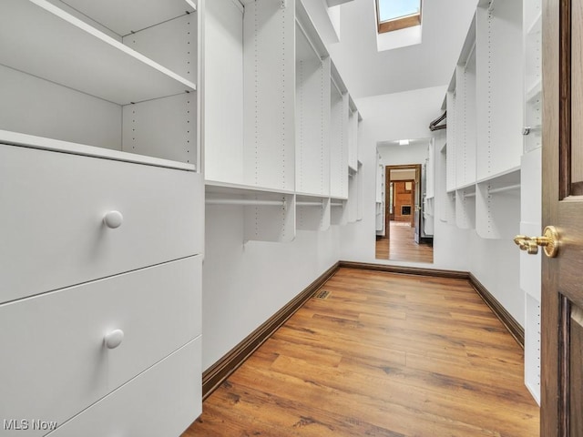 walk in closet featuring a skylight and wood finished floors