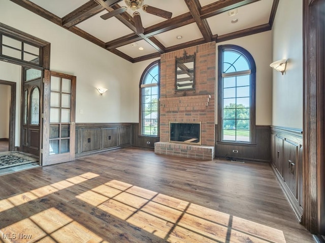 unfurnished living room with a wealth of natural light, coffered ceiling, and a fireplace