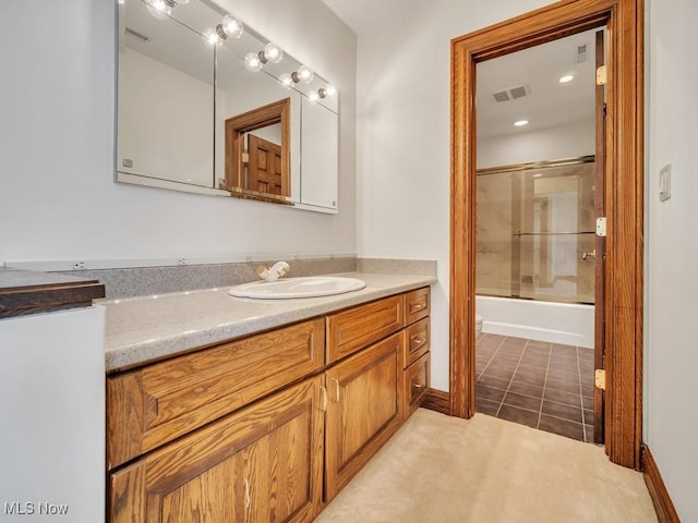 bathroom with tile patterned flooring, visible vents, vanity, and combined bath / shower with glass door