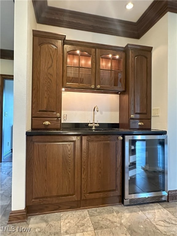 bar featuring wine cooler, ornamental molding, indoor wet bar, and a sink