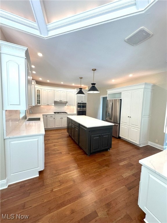 kitchen featuring dark wood-type flooring, a sink, visible vents, white cabinets, and appliances with stainless steel finishes