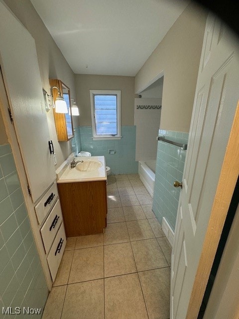 full bathroom featuring tile patterned floors, tile walls, washtub / shower combination, and vanity