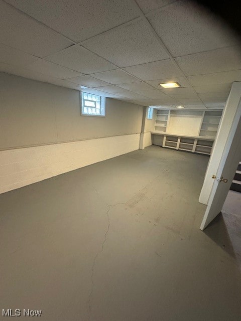 basement with a paneled ceiling