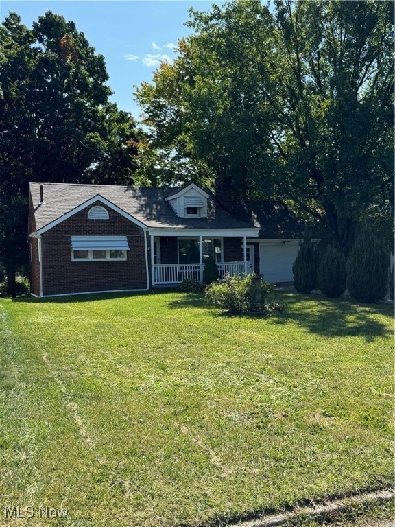 cape cod home with a front yard and covered porch