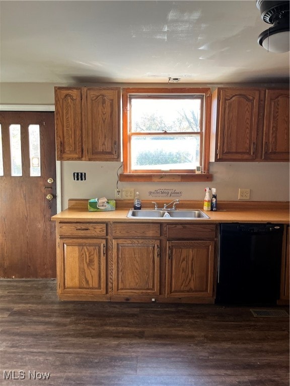 kitchen featuring dark wood-style floors, black dishwasher, light countertops, and a sink