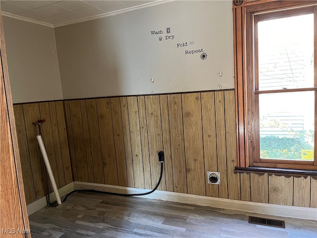 washroom featuring a wainscoted wall, laundry area, wood walls, wood finished floors, and visible vents