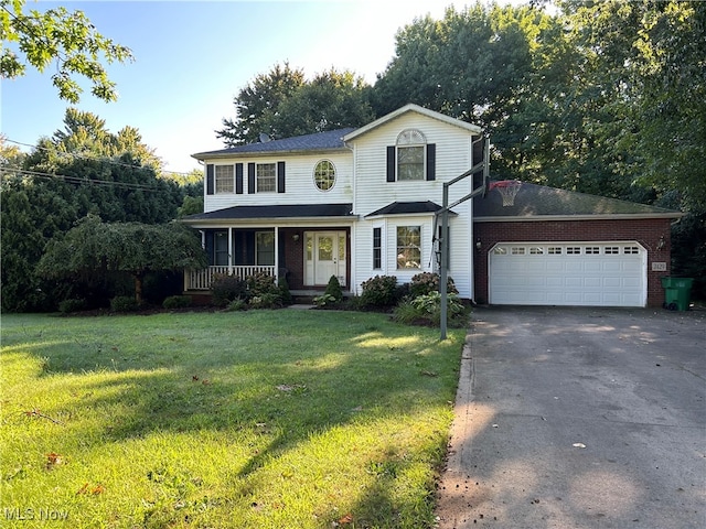 view of front of property with a front lawn, covered porch, and a garage