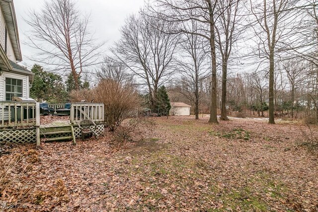 view of yard with a storage unit, a deck, and an outdoor structure