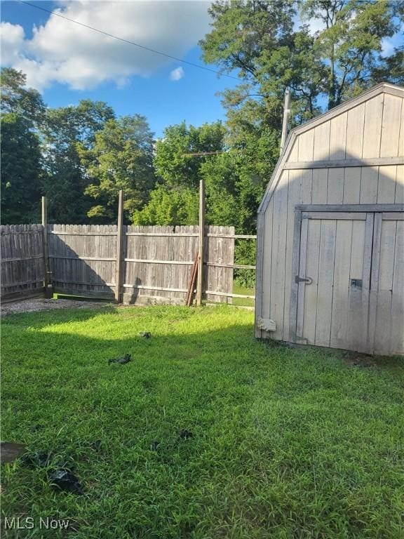 view of yard with a storage shed, an outdoor structure, and fence