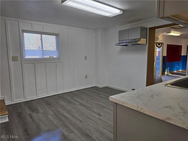 interior space with dark wood finished floors and a decorative wall