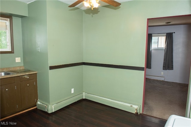 interior space with dark wood-type flooring, sink, a baseboard radiator, and ceiling fan