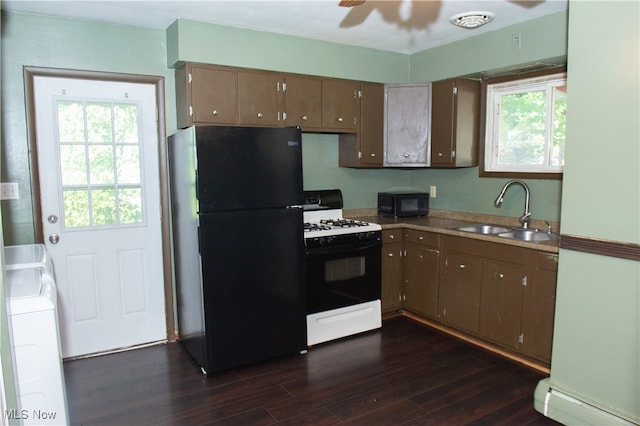 kitchen featuring dark hardwood / wood-style flooring, black appliances, washer / dryer, sink, and ceiling fan