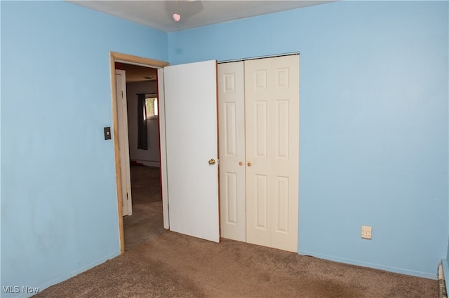 unfurnished bedroom with a baseboard radiator, a closet, and carpet floors