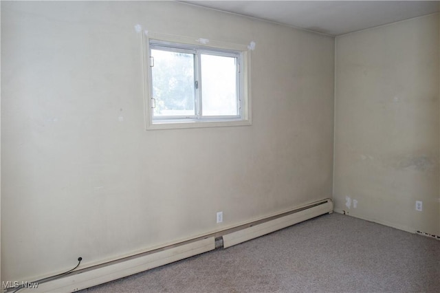 carpeted empty room featuring baseboard heating