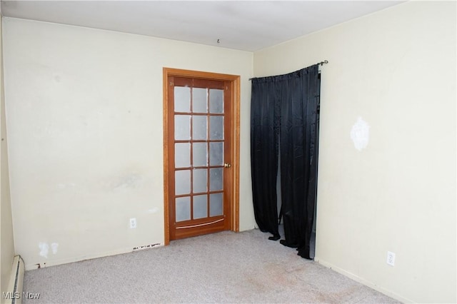 empty room featuring a baseboard radiator and carpet flooring