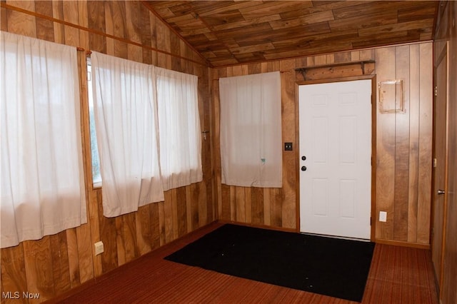 spare room with wood ceiling, vaulted ceiling, and wooden walls