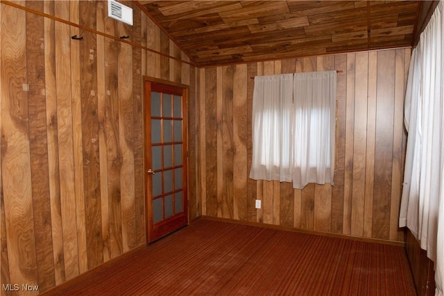 unfurnished room featuring vaulted ceiling, wood ceiling, visible vents, and wood walls