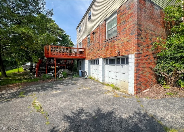 view of side of property featuring a garage and a wooden deck