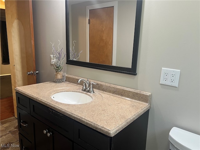 bathroom featuring vanity and toilet