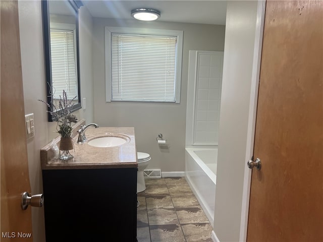 bathroom with vanity, toilet, and a washtub