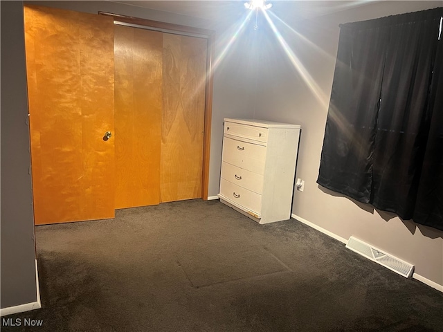 additional living space with dark colored carpet